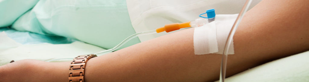 Arm of patient with attached IV.